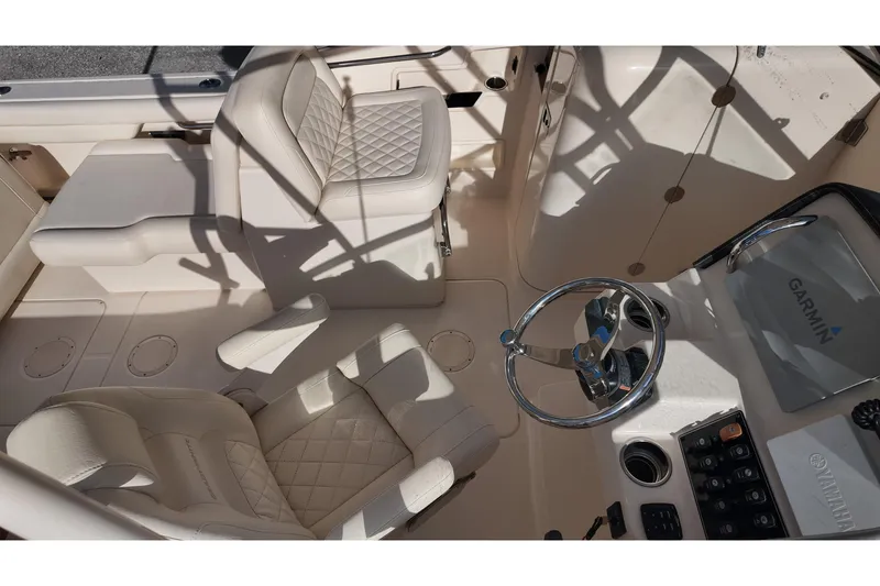 Slide: The Image of 2019 Grady-White Freedom 235 boat interior with steering wheel and Garmin navigation system. - 12