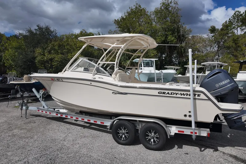 Slide: The Image of 2019 Grady-White Freedom 235 boat on trailer, parked outdoors with trees in background. - 5