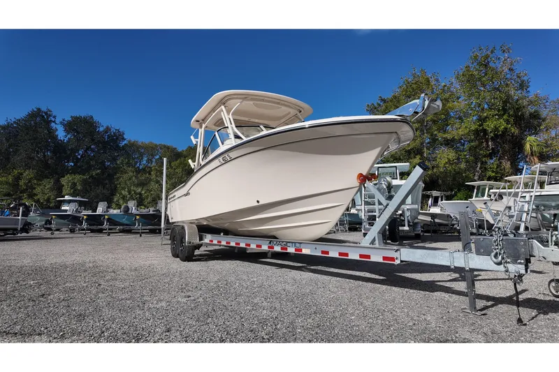 Slide: The Image of 2019 Grady-White Freedom 235 boat on trailer, parked outdoors under clear blue sky. - 6