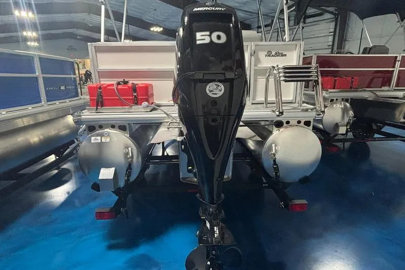 Slide: The Image of 2026 Sun Tracker Party Barge 16 DLX with Mercury 50 outboard motor in showroom. - 3