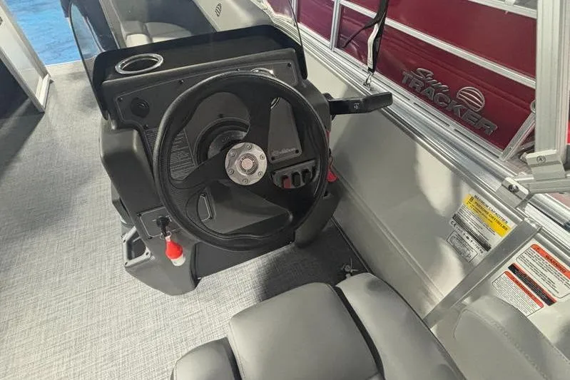 Slide: The Image of 2026 Sun Tracker Party Barge 16 DLX steering console with comfortable seating and modern controls. - 8