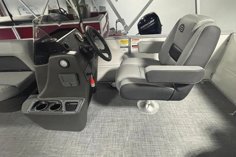 Slide: The Image of 2026 Sun Tracker Party Barge 16 DLX interior with steering console and captain's chair. - 9