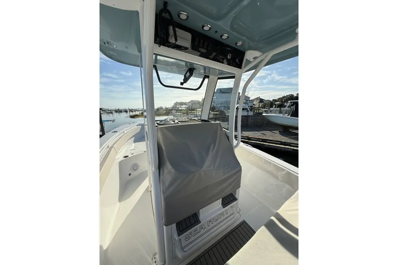 Slide: The Image of 2025 Sea Hunt Gamefish 25 boat interior with covered console, docked by the marina. - 11