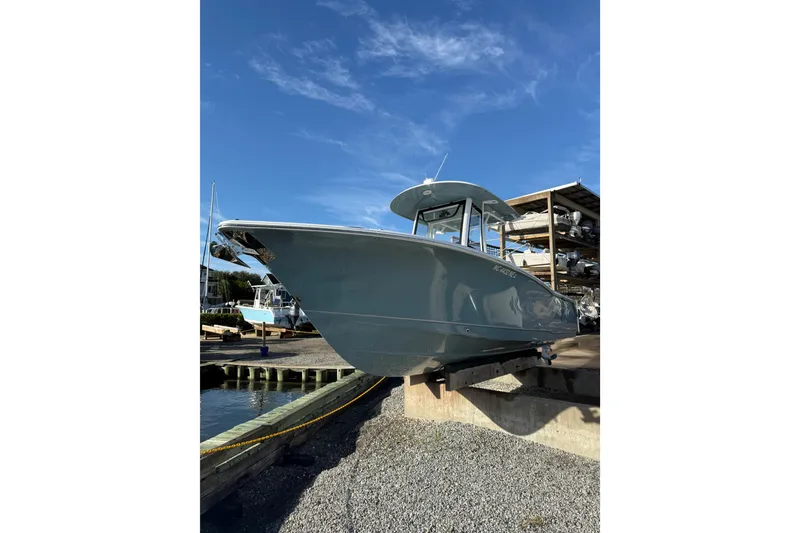 Slide: The Image of 2025 Sea Hunt Gamefish 25 boat on a dock under clear blue sky. - 6