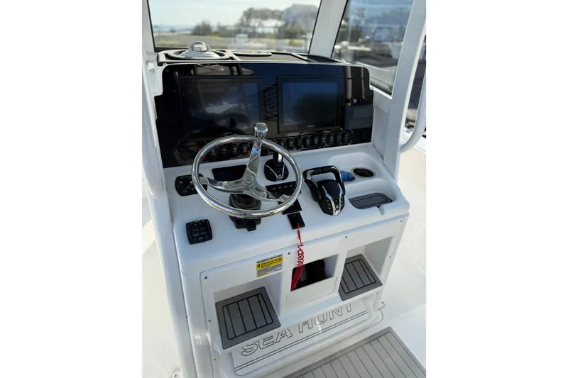 Slide: The Image of 2025 Sea Hunt Gamefish 25 boat console with steering wheel and navigation controls. - 7