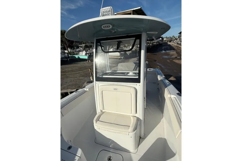 Slide: The Image of 2025 Sea Hunt Gamefish 25 boat with center console and seating, docked under clear skies. - 9