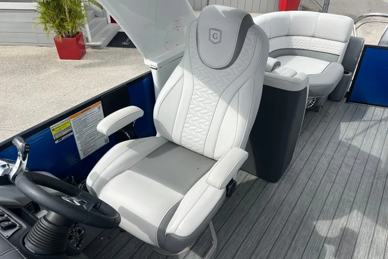 Slide: The Image of 2021 Godfrey Monaco 255 RL Tri Toon boat interior with luxurious seating and steering wheel. - 13
