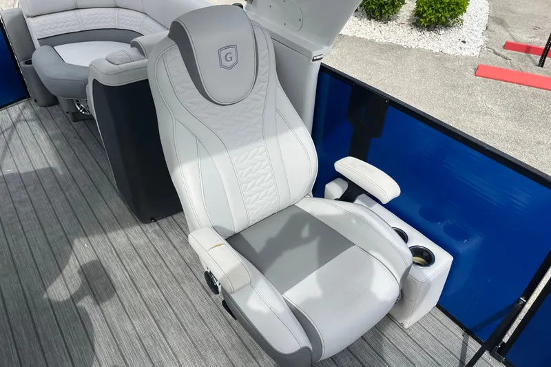 Slide: The Image of Captain's chair on 2021 Godfrey Monaco 255 RL Tri Toon boat, featuring sleek design and cup holders. - 14