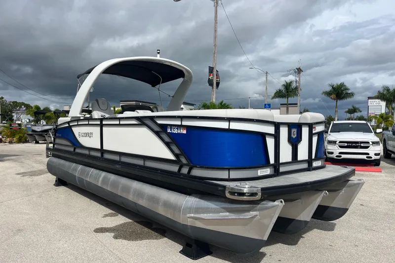 Slide: The Image of 2021 Godfrey Monaco 255 RL Tri Toon boat in a parking lot under cloudy skies. - 3