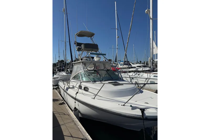 Slide: The Image of 2000 Boston Whaler 295 Conquest docked at marina under clear blue sky. - 1