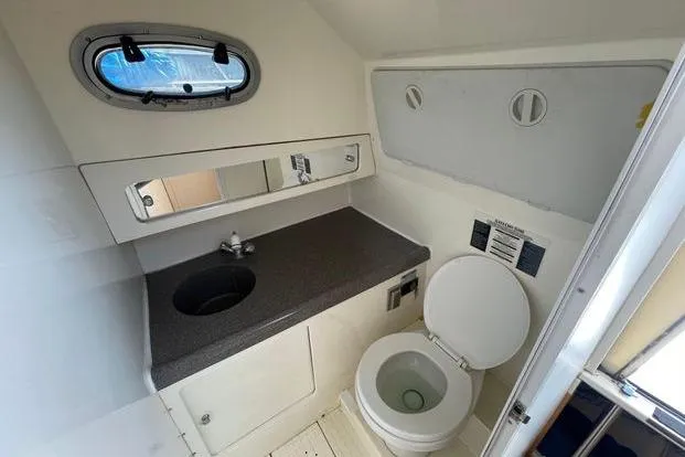 Slide: The Image of Boston Whaler 295 Conquest 2000 boat bathroom with sink, mirror, and toilet. - 10