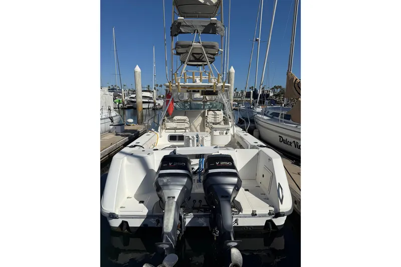 Slide: The Image of 2000 Boston Whaler 295 Conquest boat docked at marina under clear blue sky. - 2
