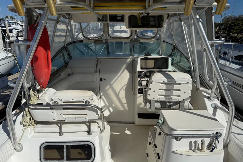 Slide: The Image of 2000 Boston Whaler 295 Conquest boat interior at marina, featuring seating and storage. - 4
