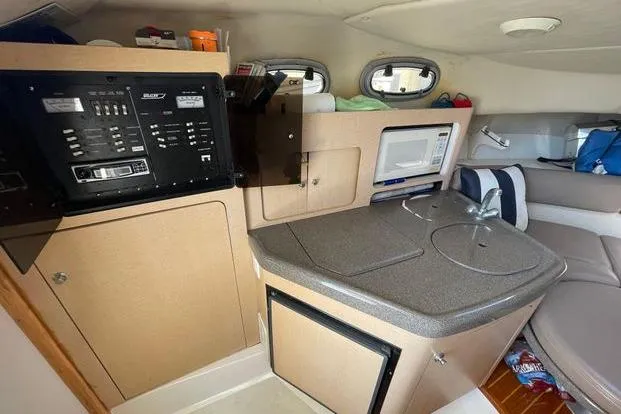 Slide: The Image of Interior of 2000 Boston Whaler 295 Conquest boat with kitchenette and seating area. - 7