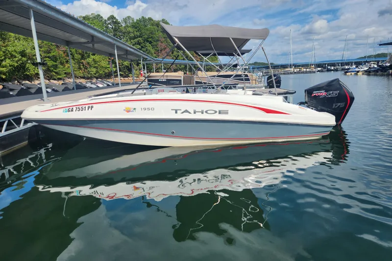 Slide: The Image of 2021 Tahoe 1950 boat docked on a sunny day, featuring a sleek design and canopy. - 4