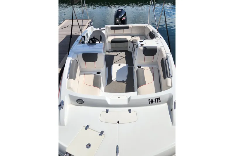 Slide: The Image of 2021 Tahoe 1950 boat with spacious seating, docked on calm water. - 7