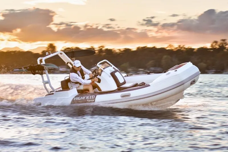 The Image of 2025 Highfield Velox 420 boat cruising on water at sunset. - 2