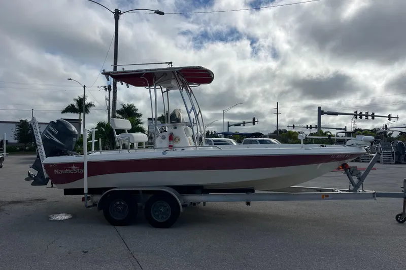 Slide: The Image of 2005 NauticStar 2200 Nautic Bay boat on trailer, parked outdoors under cloudy sky. - 3