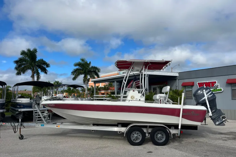 Slide: The Image of 2005 NauticStar 2200 Nautic Bay boat on trailer, parked outdoors under a cloudy sky. - 7