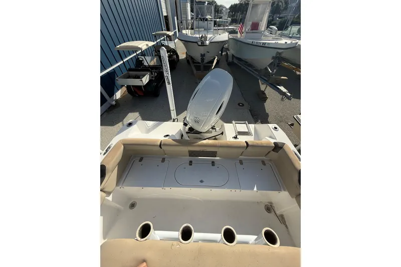 Slide: The Image of 2019 Tidewater 210 LXF boat with outboard motor, docked alongside other boats. - 10