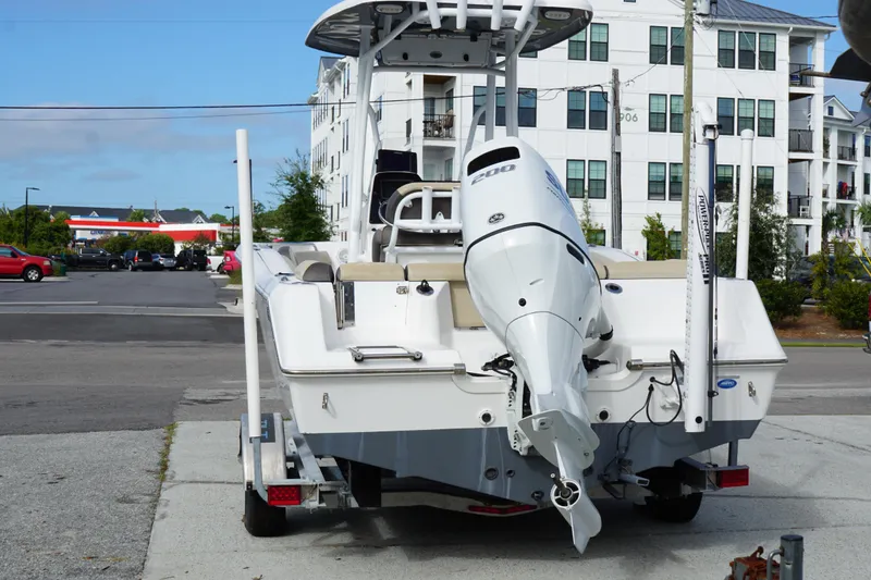 Slide: The Image of 2019 Tidewater 210 LXF boat on trailer, parked near residential buildings. - 5