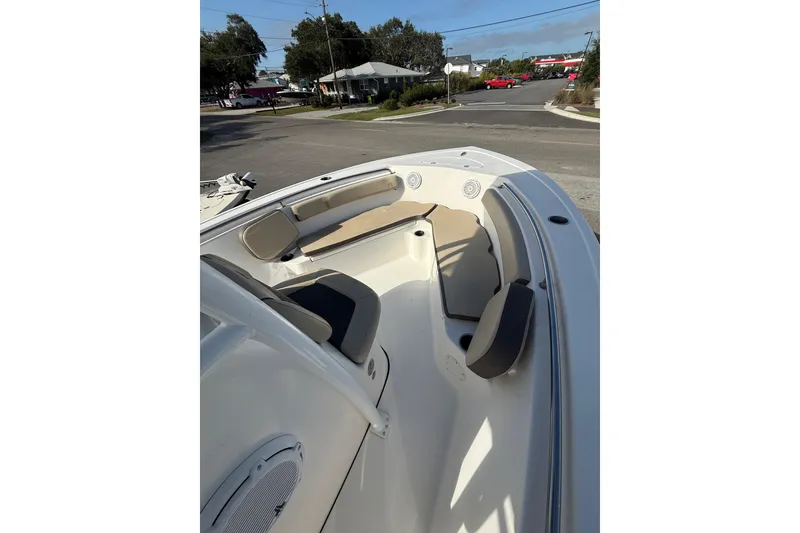 Slide: The Image of 2019 Tidewater 210 LXF boat interior with seating and speakers, parked on a street. - 9