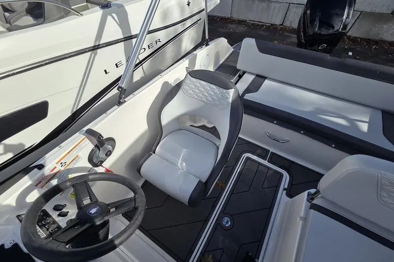 Slide: The Image of 2024 Bayliner M19 boat interior with steering wheel and seating area. - 12