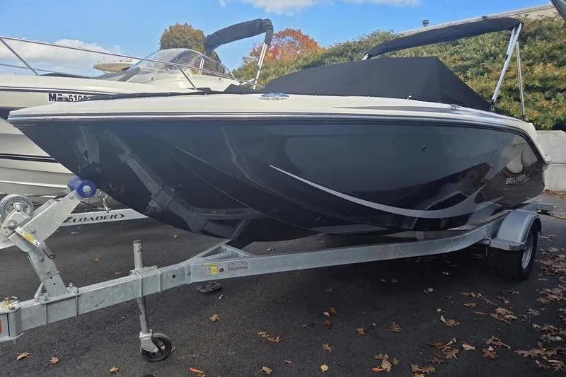 The Image of 2024 Bayliner M19 boat on trailer, parked outdoors with autumn foliage. - 2