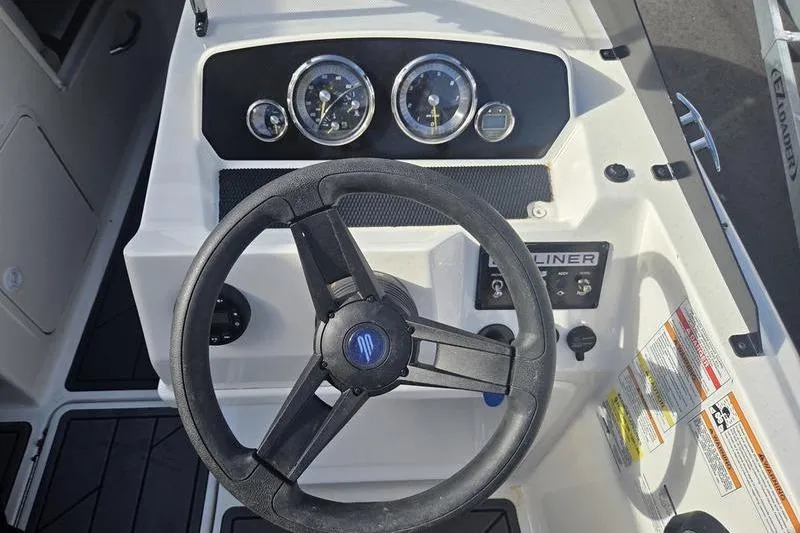 Slide: The Image of 2024 Bayliner M19 boat dashboard with steering wheel and instrument panel. - 8