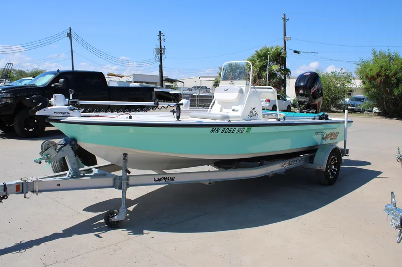 Slide: The Image of 2022 Mako 18 LTS boat on trailer, parked outdoors under clear blue sky. - 10