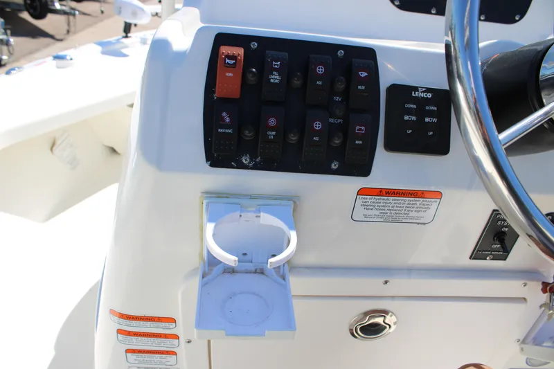 Slide: The Image of Control panel of a 2022 Mako 18 LTS boat with switches and cup holder. - 14