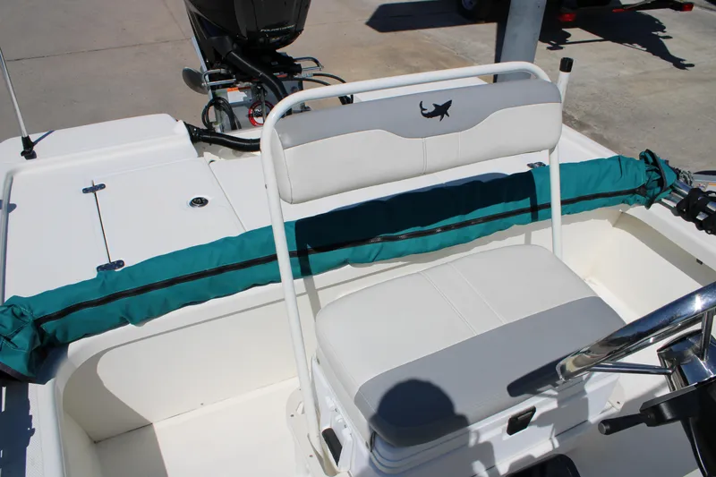 Slide: The Image of 2022 Mako 18 LTS boat interior with white seating and teal cover. - 18