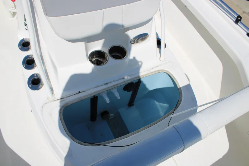 Slide: The Image of 2022 Mako 18 LTS boat interior with rod holders and open storage compartment. - 19