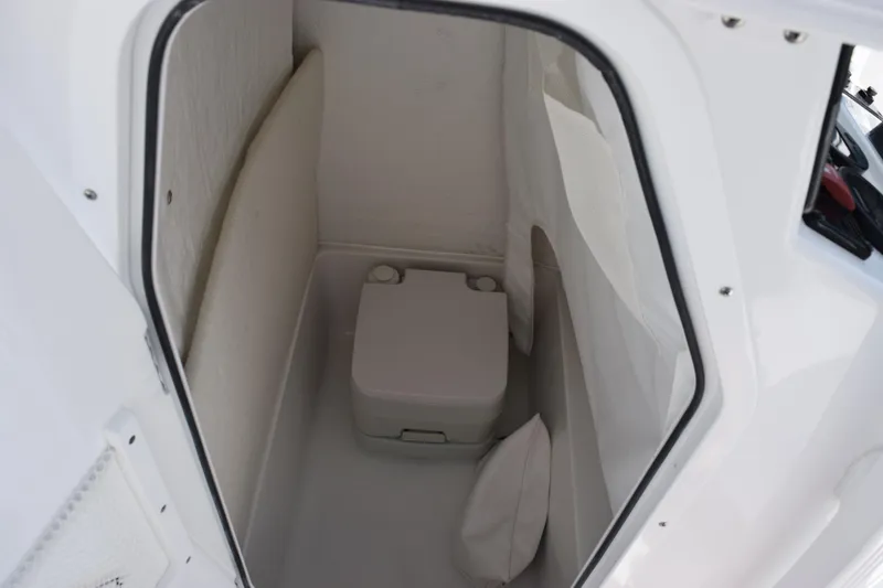 Slide: The Image of 2026 Sea Hunt Ultra 229 boat interior with compact marine toilet. - 14