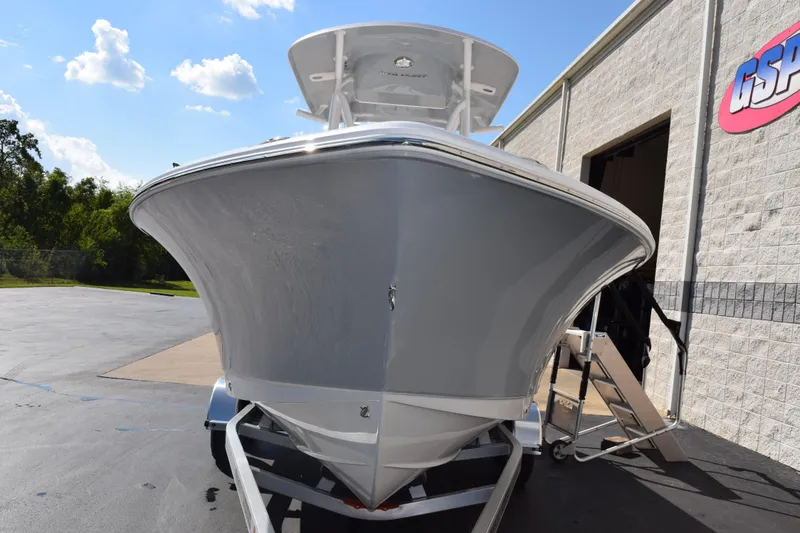 Slide: The Image of 2026 Sea Hunt Ultra 229 boat on trailer outside a building under a clear sky. - 3