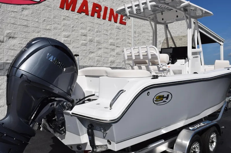 Slide: The Image of 2026 Sea Hunt Ultra 229 boat with Yamaha engine, displayed at a marine dealership. - 4