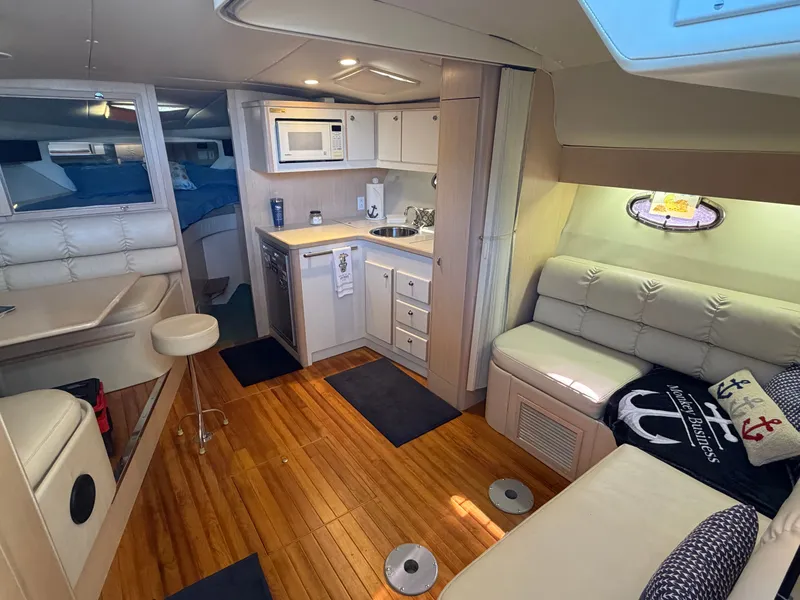 Slide: The Image of Interior of a 1995 Tiara Yachts 3500 Express, featuring a cozy cabin and kitchenette. - 13