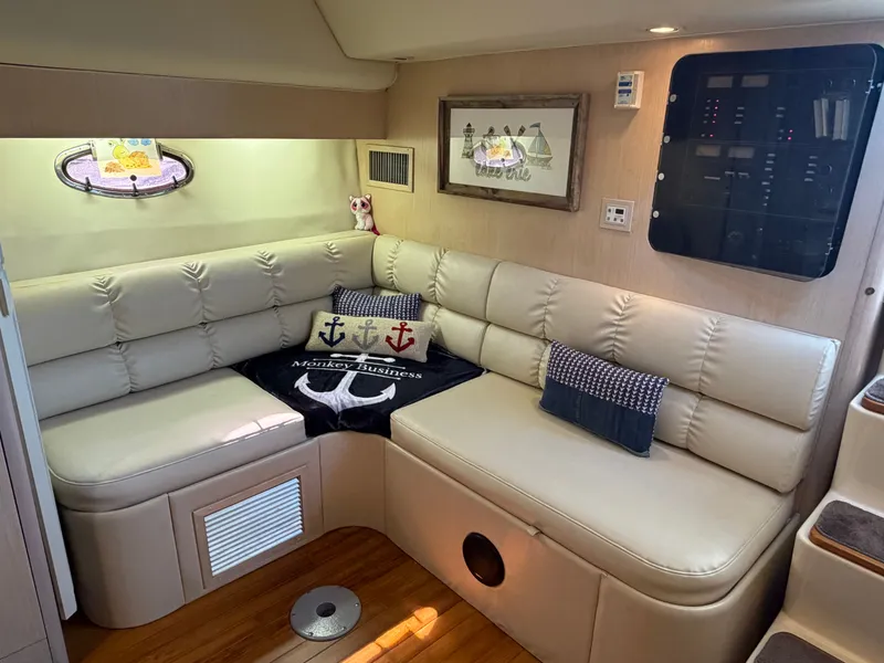 Slide: The Image of 1995 Tiara Yachts 3500 Express interior with cream leather seating and nautical decor. - 14