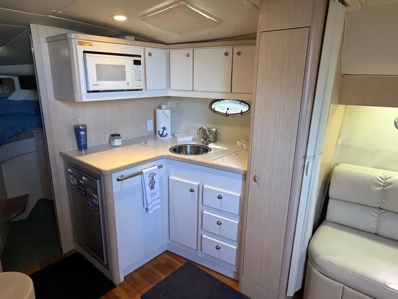 Slide: The Image of 1995 Tiara Yachts 3500 Express interior kitchen with microwave, sink, and storage cabinets. - 15