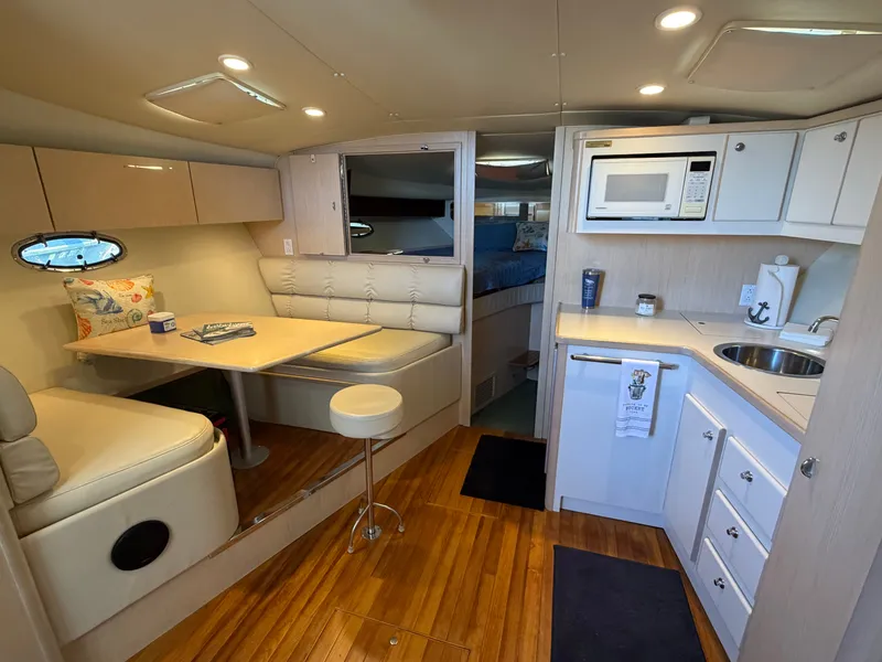 Slide: The Image of Interior of 1995 Tiara Yachts 3500 Express, featuring kitchen and dining area with wood flooring. - 17