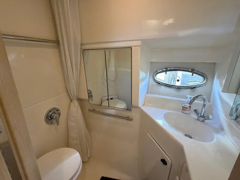 Slide: The Image of Bathroom interior of 1995 Tiara Yachts 3500 Express with sink, mirror, and porthole window. - 24