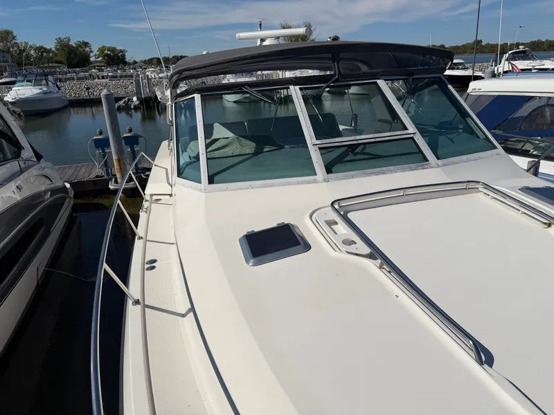 Slide: The Image of 1995 Tiara Yachts 3500 Express docked at marina, showcasing sleek design and spacious deck. - 29