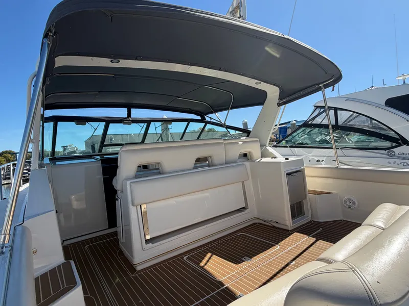 Slide: The Image of 1995 Tiara Yachts 3500 Express interior with seating and canopy, docked under clear sky. - 3