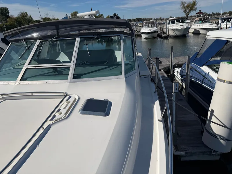 Slide: The Image of 1995 Tiara Yachts 3500 Express docked at marina, showcasing sleek design and spacious deck. - 30