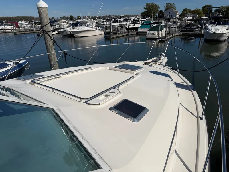 Slide: The Image of 1995 Tiara Yachts 3500 Express docked at a marina with other boats. - 31