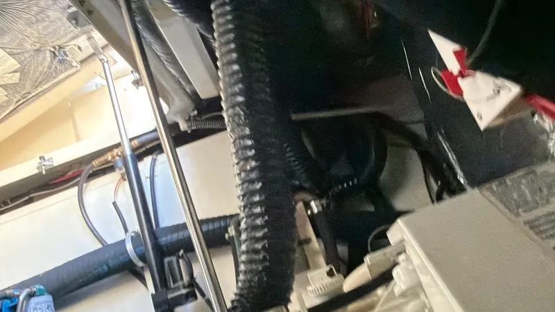 Slide: The Image of Engine compartment of a 1995 Tiara Yachts 3500 Express, showcasing hoses and mechanical components. - 35