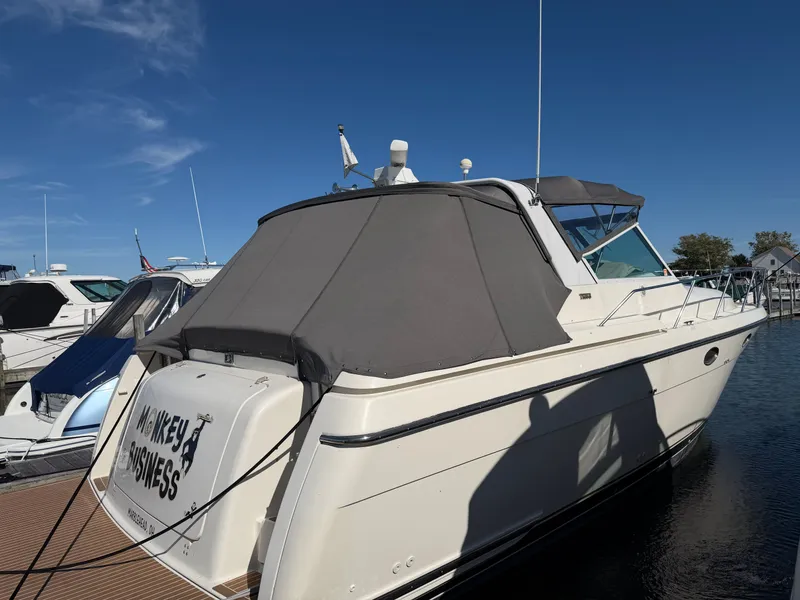 Slide: The Image of 1995 Tiara Yachts 3500 Express docked, featuring a covered cabin and sleek design. - 37