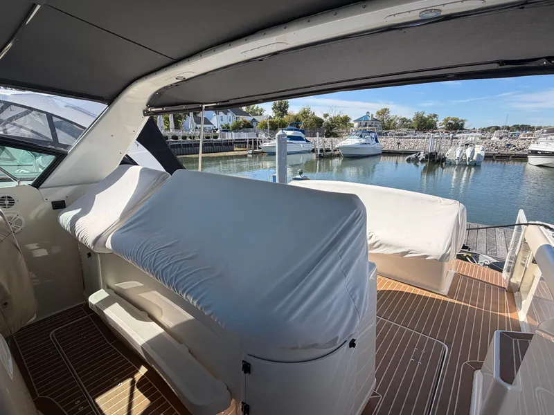 Slide: The Image of 1995 Tiara Yachts 3500 Express interior with covered seating, docked at a marina. - 39