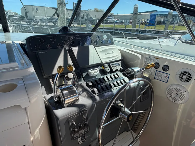 Slide: The Image of 1995 Tiara Yachts 3500 Express helm with steering wheel and navigation controls. - 7
