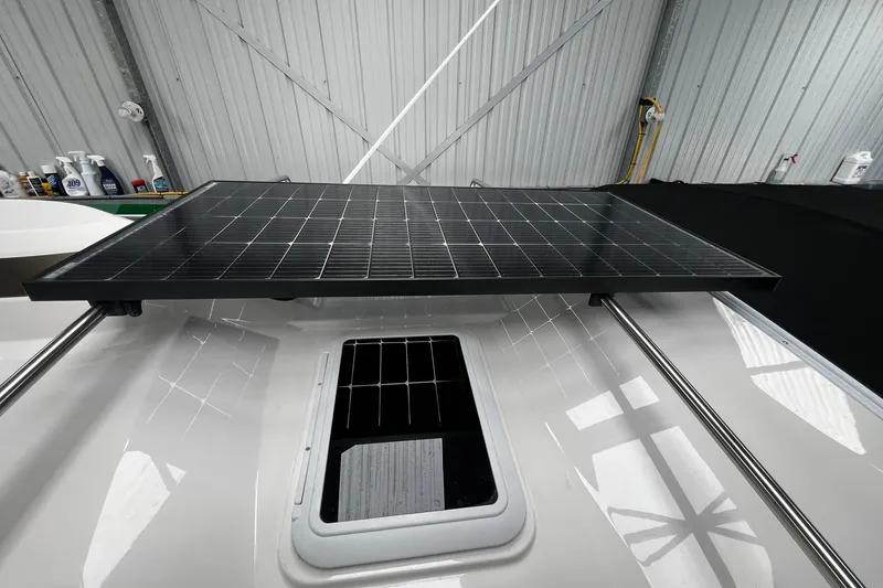 Slide: The Image of Ranger Tugs R-27 2025 model with solar panel on roof in a garage setting. - 10